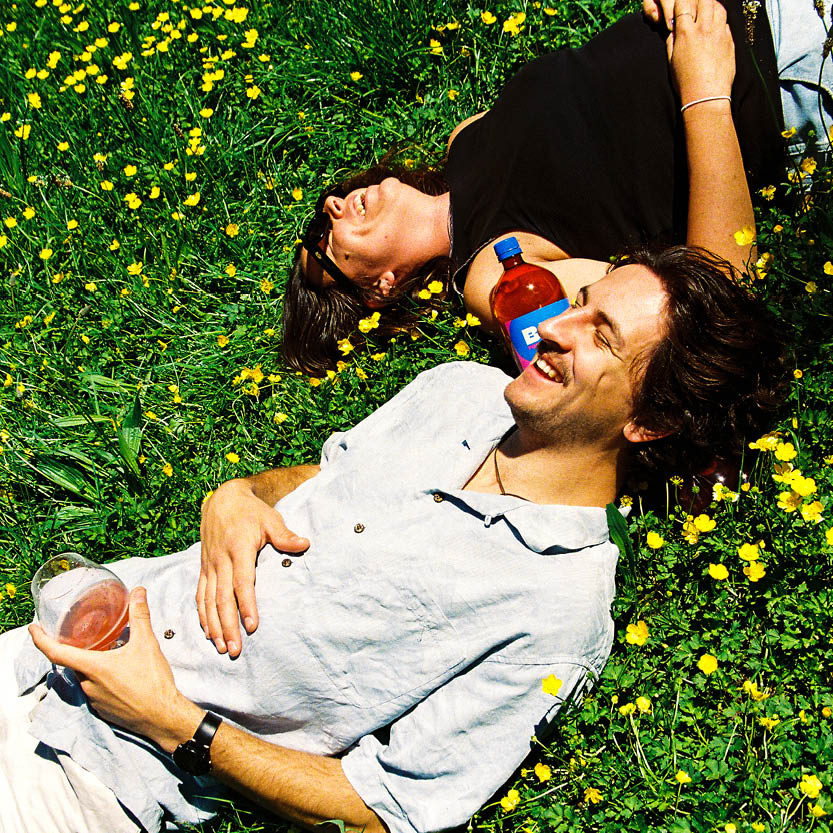 Two friends relaxing in the sun with BEE naturally brewed alcoholic soda